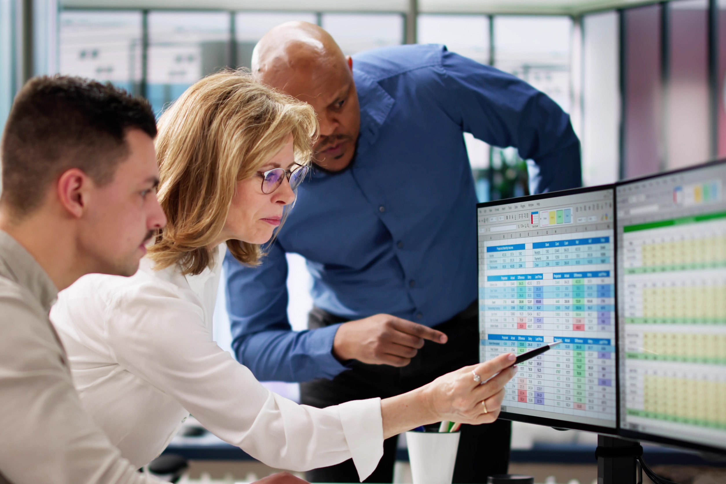 Supervisor checking data quality dashboard on monitor